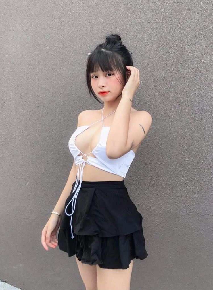 Gái xinh mặc váy ngắn xếp ly caro khoe vóc dáng cân đối và nụ cười rạng rỡ.