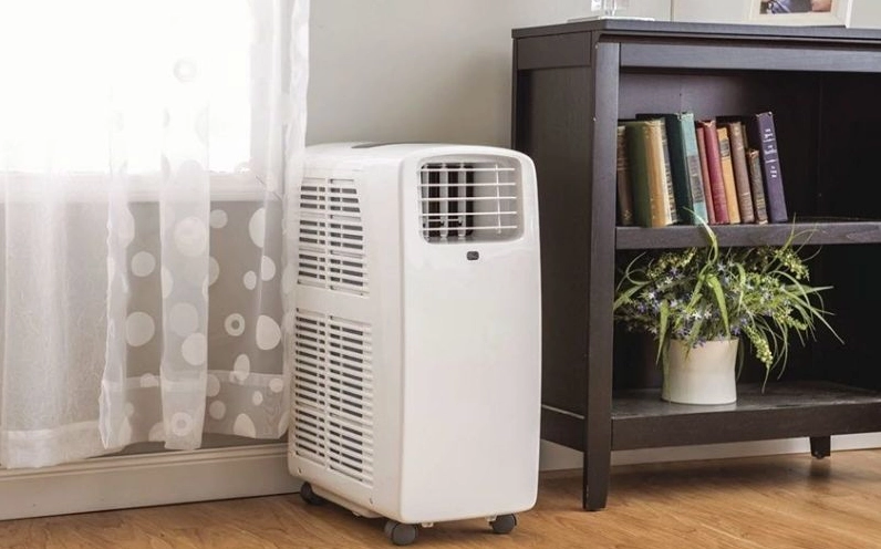 Một chiếc máy hút ẩm màu trắng đang hoạt động trong phòng khách, giúp không khí khô ráo hơn.