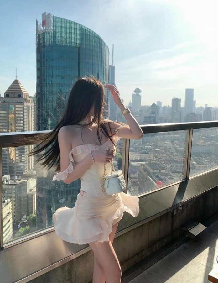 Một cô gái xinh đẹp gợi cảm trong chiếc váy ngắn trắng tinh khôi tạo dáng quyến rũ.