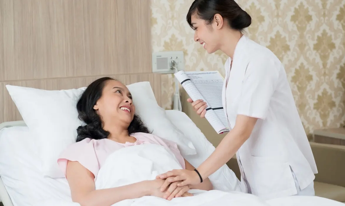 Nữ điều dưỡng đang chăm sóc và động viên một bệnh nhân nam, thể hiện sự tận tâm trong y tế.